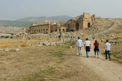 Students walking up dirt road to ruins.